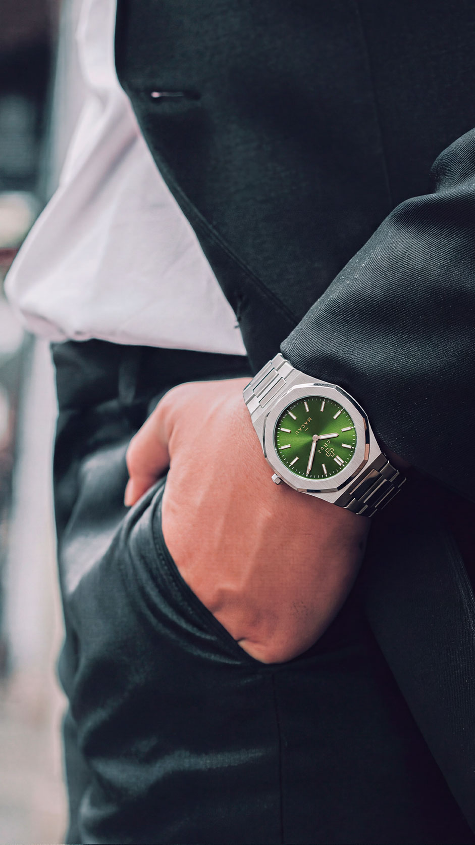 Cruz Watches Macau verde no pulso, com roupa de alfaiataria.