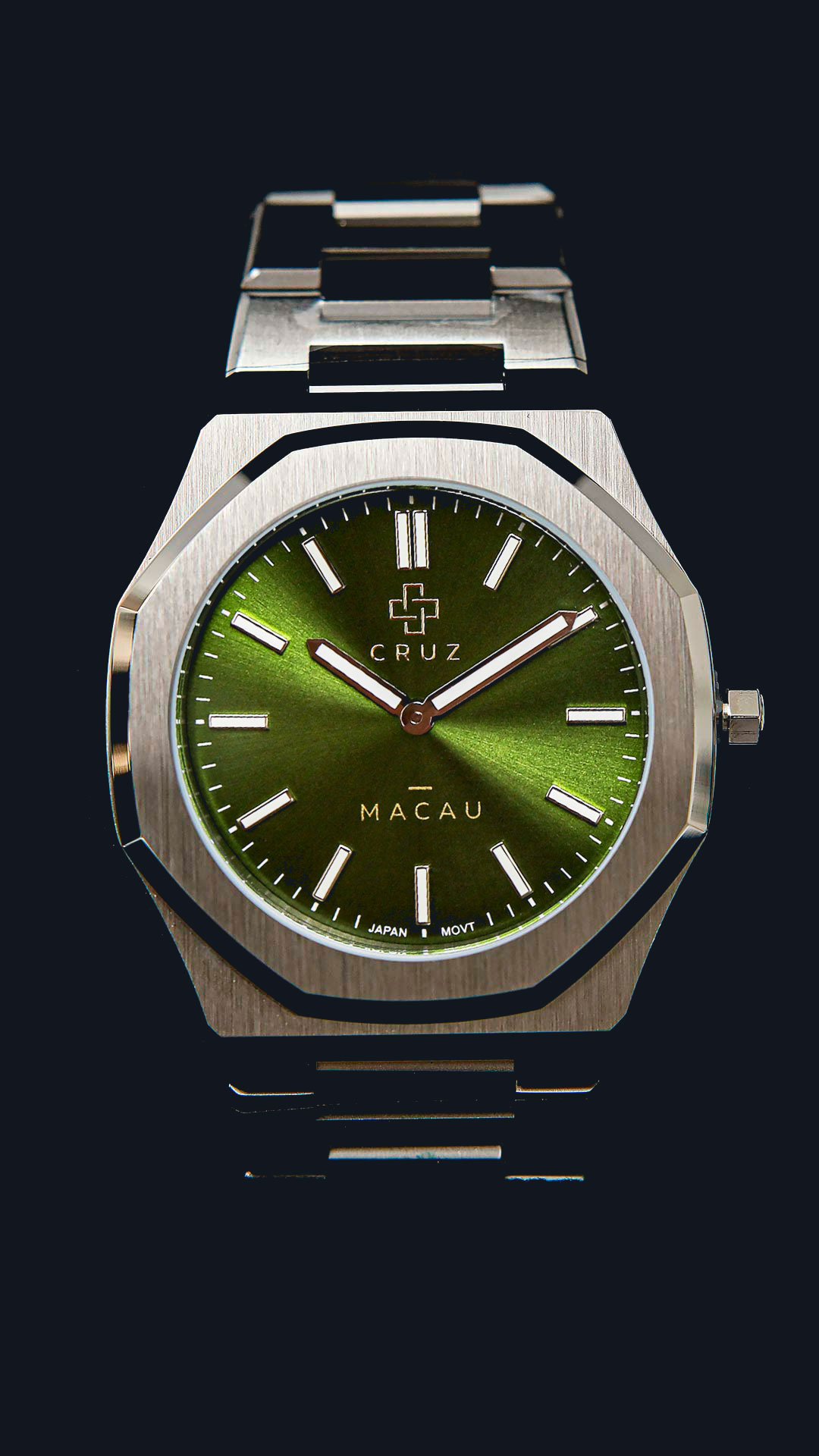 Cruz Watches Macau com mostrador verde, caixa prateada e pulseira de aço, sobre fundo escuro.